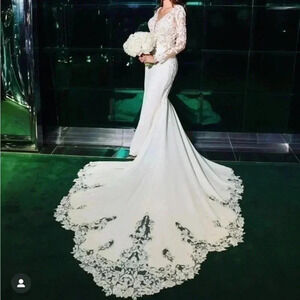 This mermaid-style gownwith a backless design, lace sleeves, and a V-nec…​